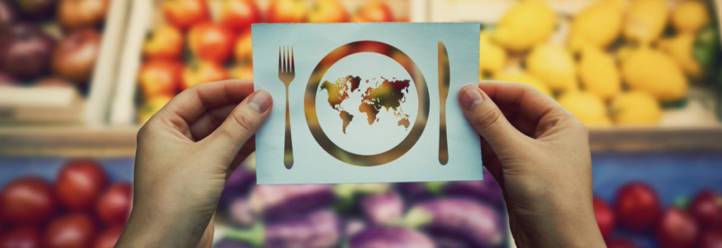 Hand holding global food cuisine concept over market background.